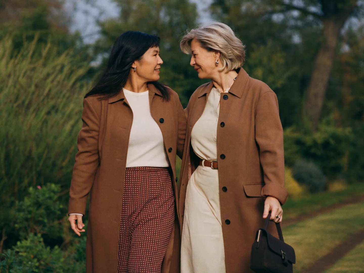 Two women strolling together along a garden path.