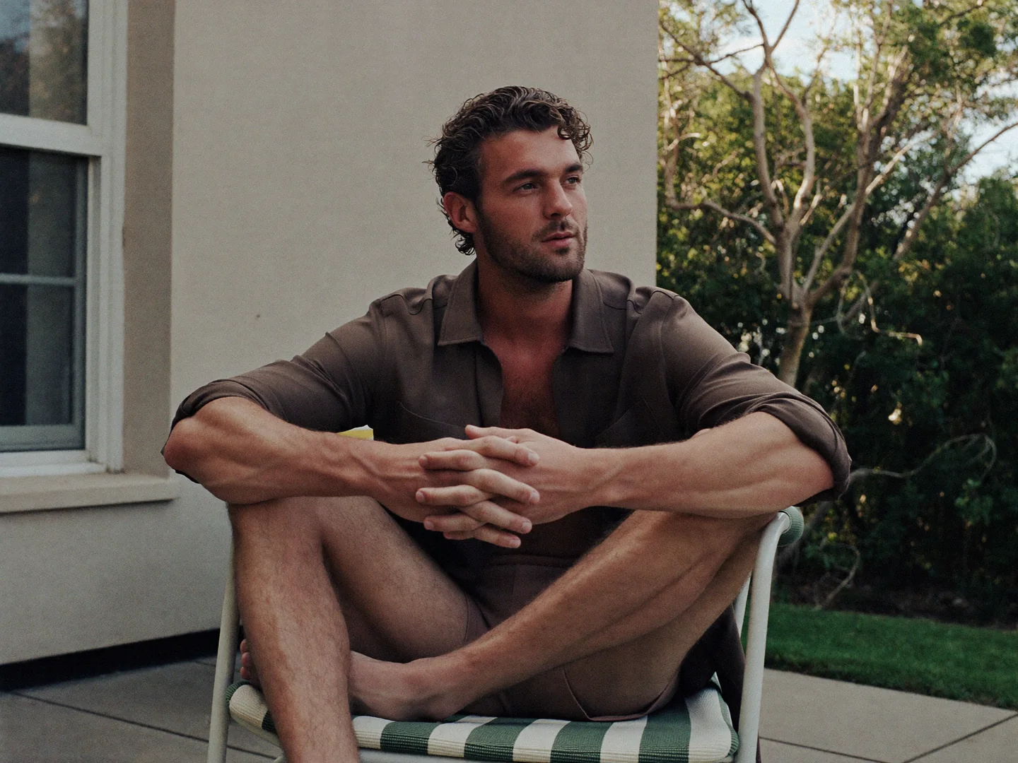 A man pausing on a garden terrace.