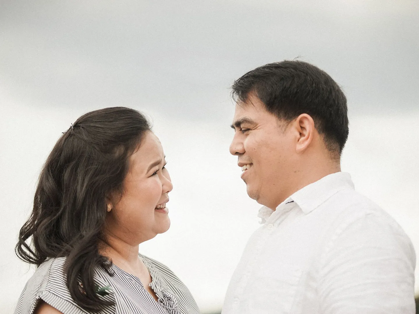 A woman and man looking at each other outdoors.