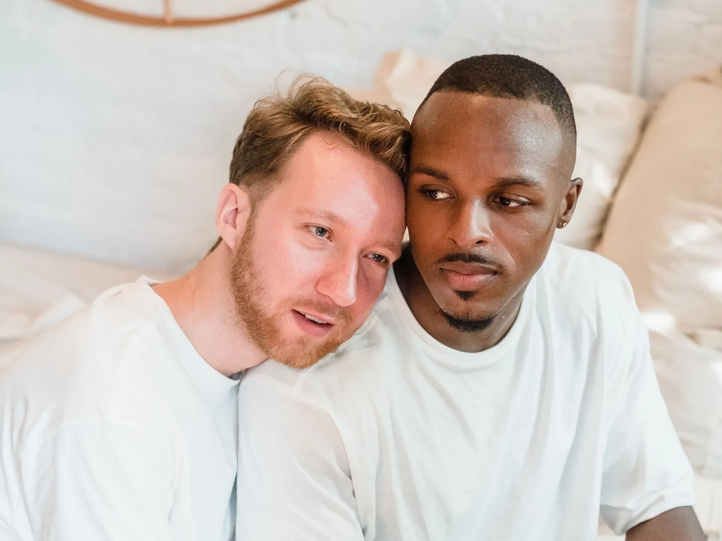 Two men sitting close together at home.