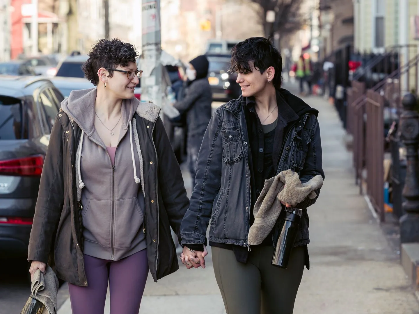 Two women walking together and holding hands.